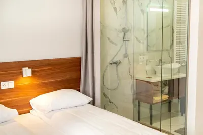 a bedroom with a shower and a bed and a sink at Agawa restauracja&Hotel in Dębno