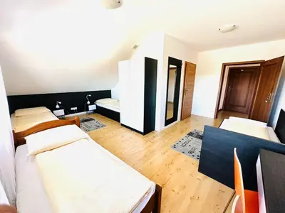 a room with three beds and a wooden floor at Agawa restauracja&Hotel in Dębno