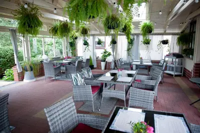 a restaurant with tables and chairs in a room with windows at Agawa restauracja&Hotel in Dębno