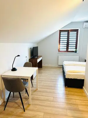 a room with a bed and a desk and a bed and a table at Agawa restauracja&Hotel in Dębno