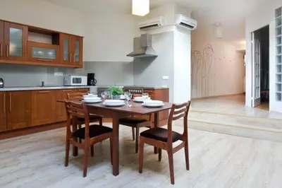 a kitchen with a wooden table and chairs in a room at Apartament - Old Town in Kraków