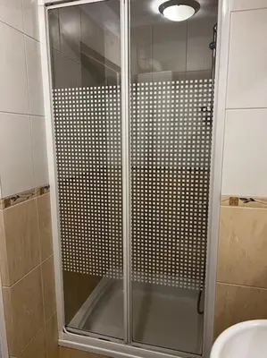 a shower with a glass door in a bathroom at Apartament - Old Town in Kraków