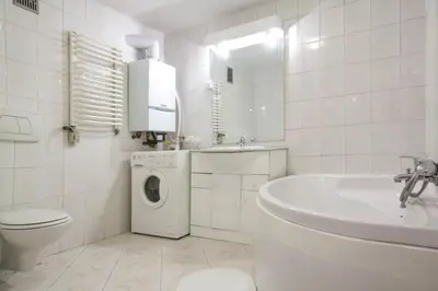 a white bathroom with a washing machine and a sink at Apartament - Old Town in Kraków