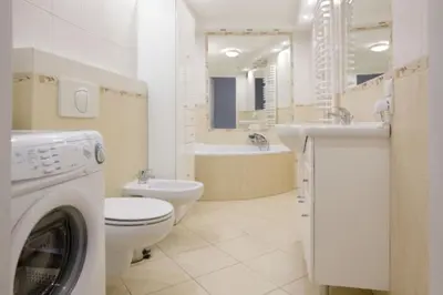 a bathroom with a washer and a toilet and a sink at Apartament - Old Town in Kraków