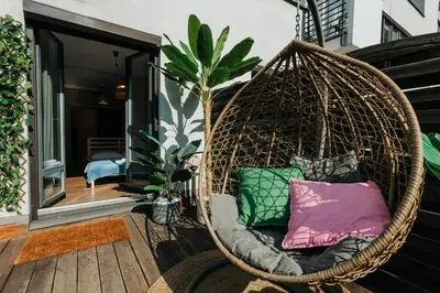 a hanging rattan chair with pillows on a porch at ICE next to the Wawel Castle Free Parking Two Cars in Kraków