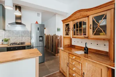 a kitchen with wooden cabinets and a refrigerator at ICE next to the Wawel Castle Free Parking Two Cars in Kraków