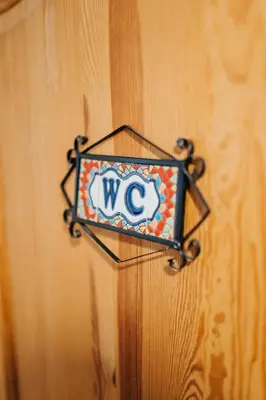 a w sign hanging on a wooden wall at ICE next to the Wawel Castle Free Parking Two Cars in Kraków