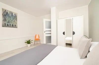a white bedroom with a bed and a mirror at 1 bedroom Apartment with Terrace - Wawrzyńca 21 in Kraków