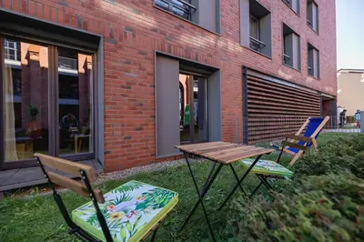 two chairs and a table in front of a building at 1 bedroom Apartment with Terrace - Wawrzyńca 21 in Kraków