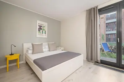 a white bedroom with a bed and a window at 1 bedroom Apartment with Terrace - Wawrzyńca 21 in Kraków
