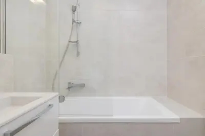 a white bathroom with a tub and a sink at 1 bedroom Apartment with Terrace - Wawrzyńca 21 in Kraków