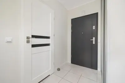 a black door in a white room with a tile floor at Apartment with Terrace - Wawrzyńca 21 Street in Kraków
