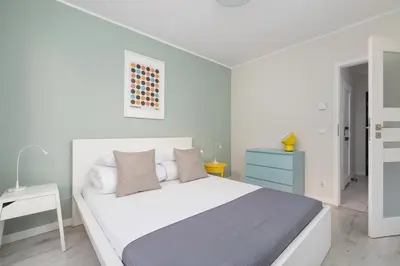 a white bedroom with a bed and a blue dresser at Apartment with Terrace - Wawrzyńca 21 Street in Kraków