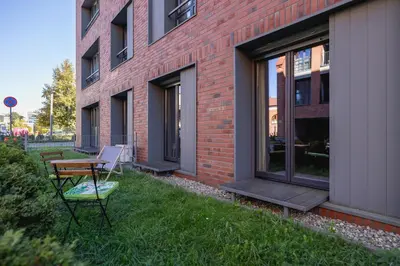 a patio with a table and chairs next to a brick building at Apartment with Terrace - Wawrzyńca 21 Street in Kraków