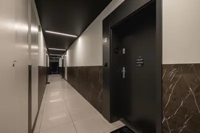 a hallway with black doors and a tile floor at Apartment with Terrace - Wawrzyńca 21 Street in Kraków