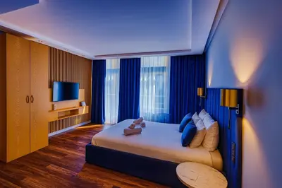 a hotel room with a large bed with blue curtains at Sweet Dreams Apartments Kazimierz in Kraków