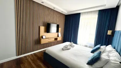 a bedroom with a bed with blue pillows and a television at Sweet Dreams Apartments Kazimierz in Kraków