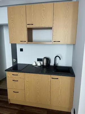 a kitchen with wooden cabinets and a sink at Sweet Dreams Apartments Kazimierz in Kraków