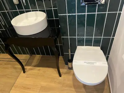 a bathroom with a toilet and a chair and a sink at Sweet Dreams Apartments Kazimierz in Kraków