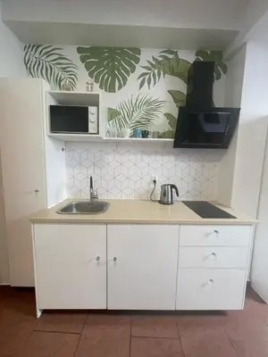 a white kitchen with a sink and a microwave at Apartament Solny Wieliczka Centrum 3 in Wieliczka