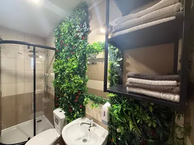 a bathroom with a sink and a mirror with plants at Apartament Solny Wieliczka Centrum 3 in Wieliczka