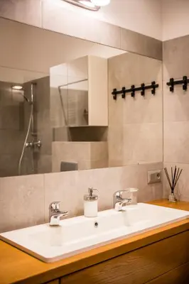 a bathroom with a white sink and a mirror at Krowoderska Residence WAWELOFTS in Kraków