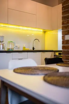 a kitchen with white counter tops and yellow walls at Krowoderska Residence WAWELOFTS in Kraków