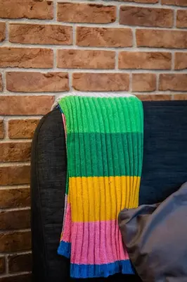 a colorful blanket on the back of a couch at Krowoderska Residence WAWELOFTS in Kraków