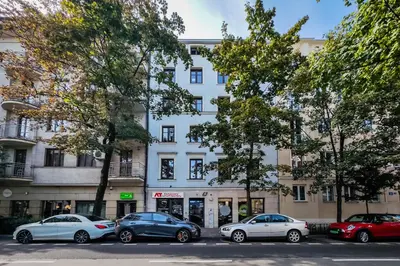 a white building with cars parked in front of it at Krowoderska Residence WAWELOFTS in Kraków