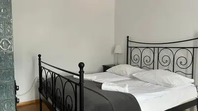 a bedroom with a black bed with white sheets at P&J Apartments Koletek in Kraków