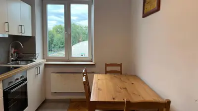 a kitchen with a wooden table and a window at P&J Apartments Koletek in Kraków
