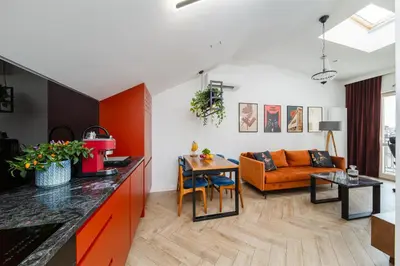a kitchen and living room with an orange couch at Horizon Apartments - Luxury Studio, Old Town in Kraków