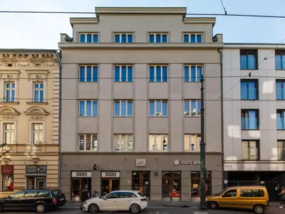 a large building with cars parked in front of it at Horizon Apartments - Luxury Studio, Old Town in Kraków