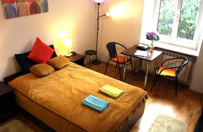 a bedroom with a bed and a table with chairs at Anna, City Center in Kraków