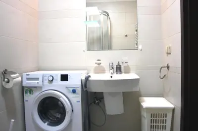 a bathroom with a washing machine and a sink at Anna, City Center in Kraków
