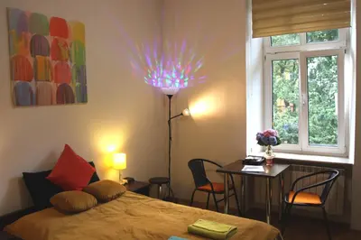 a bedroom with a bed and a table and a lamp at Anna, City Center in Kraków