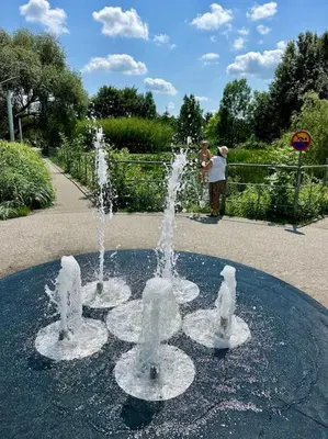 two water fountains in a park with people taking pictures at Kaczary Deluxe 56m2 in Kraków