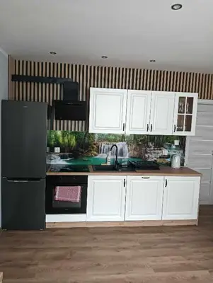 a kitchen with white cabinets and a black refrigerator at Apartament Koszarawa in Koszarawa