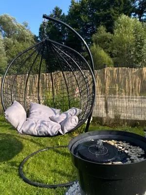 a bird cage sitting next to a fire pit at Apartament Koszarawa in Koszarawa