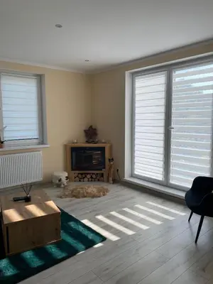 a living room with two large windows and a couch at Apartament Koszarawa in Koszarawa