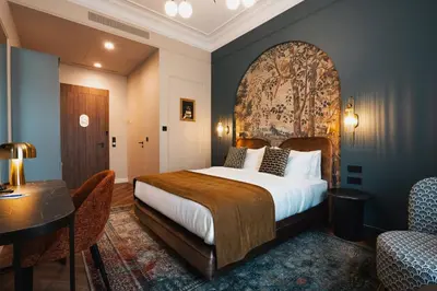 a bedroom with a bed and a table and chairs at Hotel Indigo Krakow - Wawel Castle by IHG in Kraków