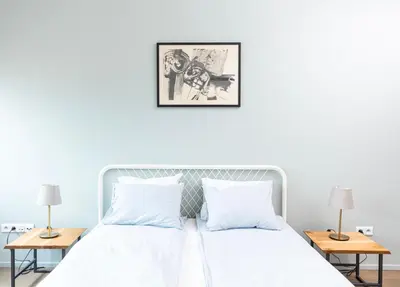 a bedroom with a white bed with two tables at Modern House in Old Town Numero 7 in Kraków