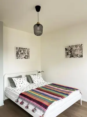 a white bedroom with a white bed with a striped blanket at Modern House in Old Town Numero 7 in Kraków