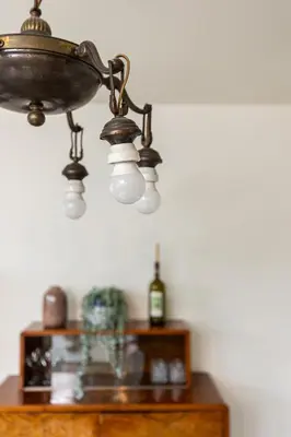 a chandelier hanging over a table with a bottle of wine at Modern House in Old Town Numero 7 in Kraków