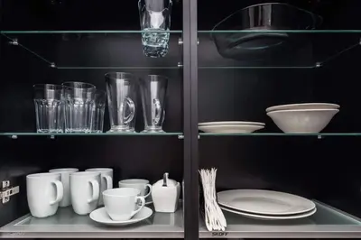 a shelf filled with plates and cups and dishes at Malila Premium Apartaments Cracow City Center Rtm Zbigniewa Dunin Wąsowicza 3 in Kraków