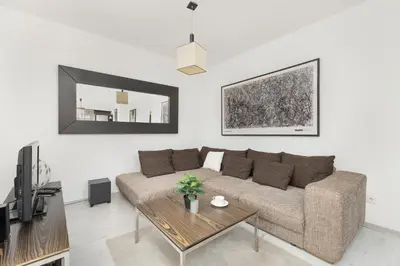 a living room with a couch and a table at Przestronny Apartament w Krakowie z Biurkiem, Parkingiem i Wanną by Noclegi Renters in Kraków