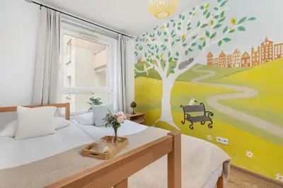 a bedroom with a tree mural on the wall at Przestronny Apartament w Krakowie z Biurkiem, Parkingiem i Wanną by Noclegi Renters in Kraków