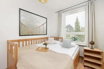 a bedroom with two beds and a window with a bridge at Przestronny Apartament w Krakowie z Biurkiem, Parkingiem i Wanną by Noclegi Renters in Kraków