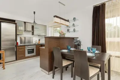 a kitchen with a wooden table and a dining room at Przestronny Apartament w Krakowie z Biurkiem, Parkingiem i Wanną by Noclegi Renters in Kraków