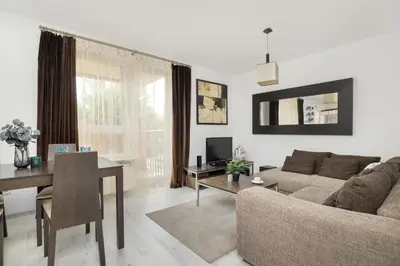 a living room with a couch and a table at Przestronny Apartament w Krakowie z Biurkiem, Parkingiem i Wanną by Noclegi Renters in Kraków